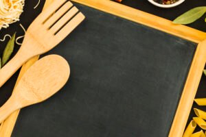 overhead-view-wooden-spoon-spatula-blank-slate-with-pasta-ingredients